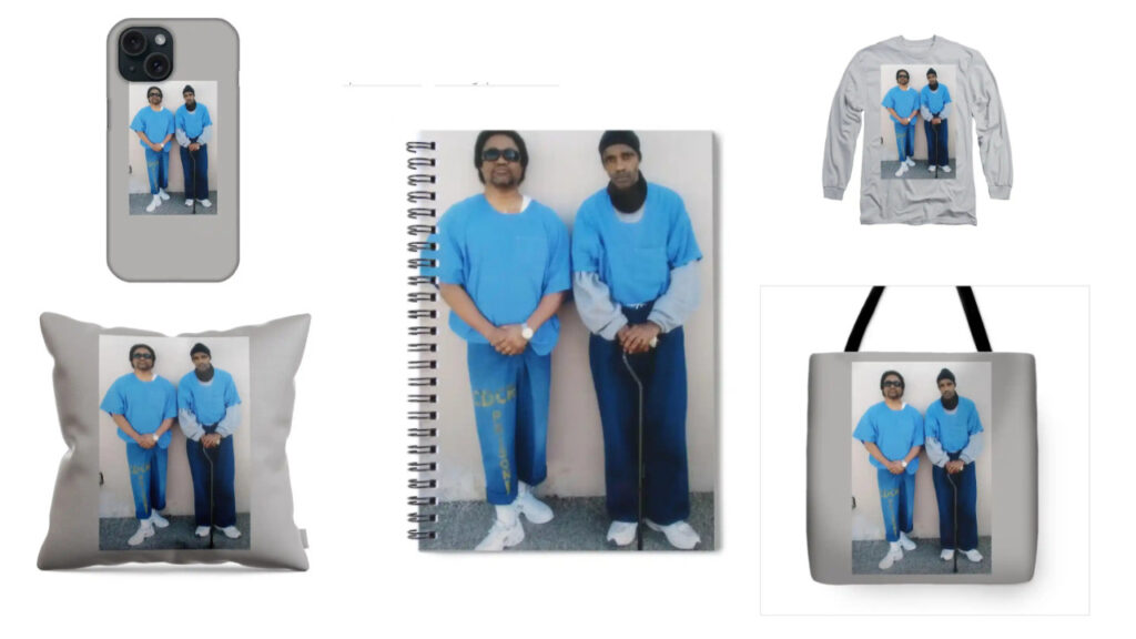 A collage of products featuring the image of prison artists C-Note and Joedee. The products include a phone case, spiral notebook, long-sleeve shirt, throw pillow, and tote bag. Each item displays the same photograph of the two artists standing side by side in blue prison uniforms, with C-Note on the left and Joedee on the right. The background of each product is a neutral gray, allowing the image to stand out prominently. These items are part of a merchandise collection available on BlackAugust.art.