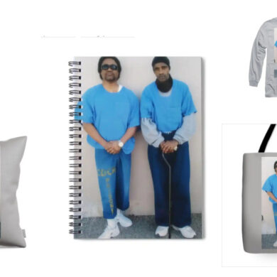 A collage of products featuring the image of prison artists C-Note and Joedee. The products include a phone case, spiral notebook, long-sleeve shirt, throw pillow, and tote bag. Each item displays the same photograph of the two artists standing side by side in blue prison uniforms, with C-Note on the left and Joedee on the right. The background of each product is a neutral gray, allowing the image to stand out prominently. These items are part of a merchandise collection available on BlackAugust.art.